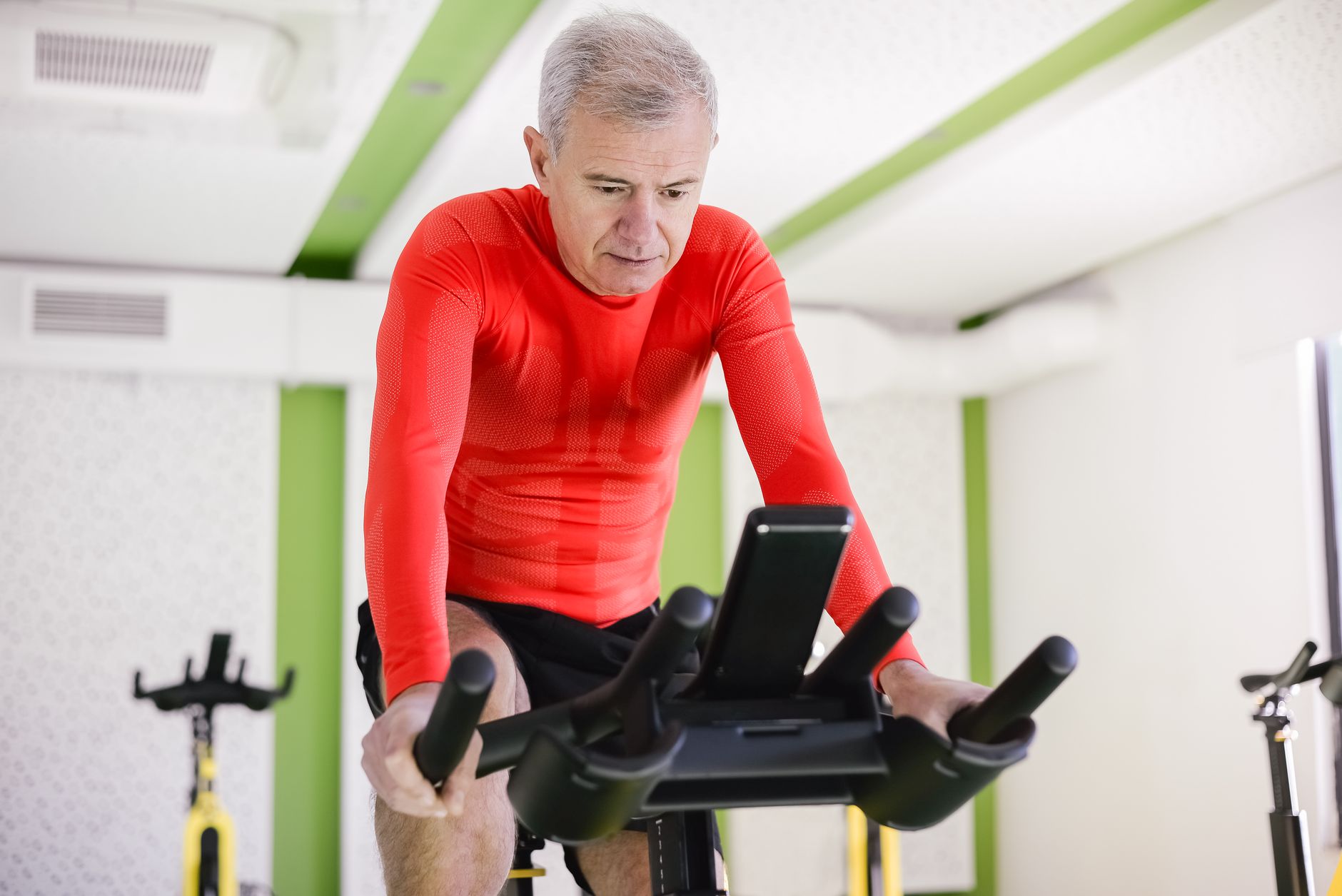 Quel vélo d'appartement choisir quand — senior utilisant un vélo d'appartement à domicile